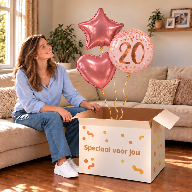 Een jarige met 20 Jaar Trosje Roze/Rose Goud boven een open Speciaal voor jou-doos in een warme woonkamer.