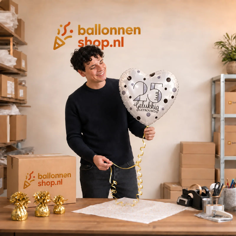 Jesse houdt de 25 Jaar Getrouwd Helium Ballon vast in de warme werkplaats van Ballonnenshop.nl.