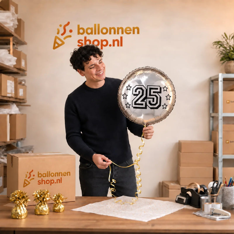 Jesse houdt de 25 Jaar Helium Ballon Zilver vast in de warme werkplaats van Ballonnenshop.nl.