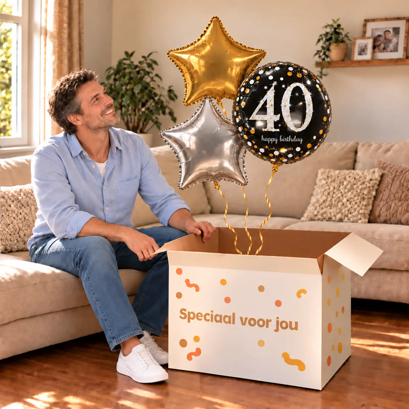 Een jarige met 40 Jaar Trosje Zilver/Zwart/Goud boven een open Speciaal voor jou-doos in een warme woonkamer.