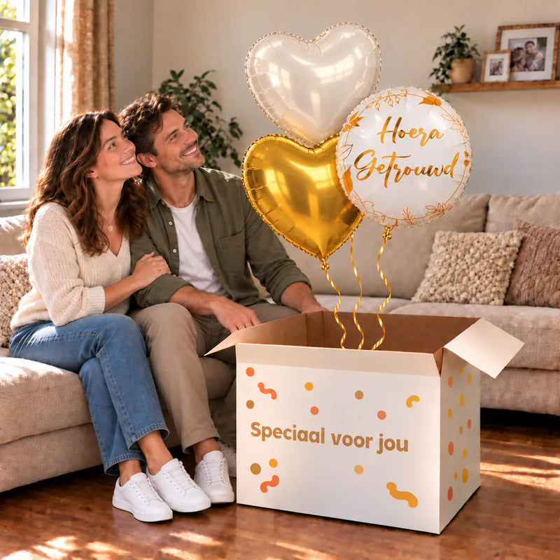 Een feestelijk huwelijksmoment met Hoera Getrouwd Trosje Ballonnen boven een open Speciaal voor jou-doos in een warme woonkamer.