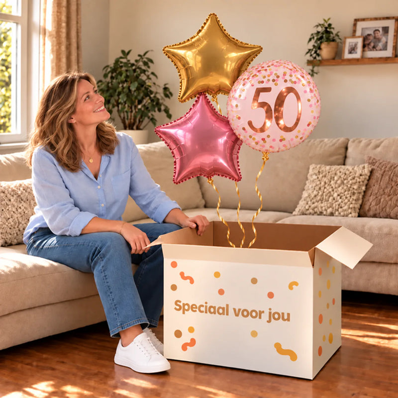 Een jarige met 50 Jaar Trosje Roze/Goud/Rose Goud boven een open Speciaal voor jou-doos in een warme woonkamer.