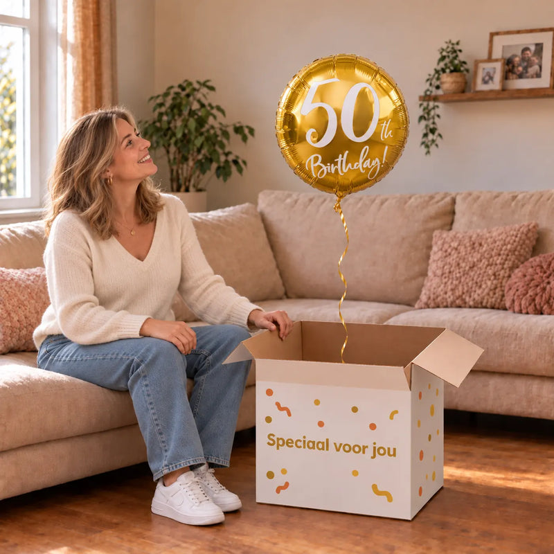 Vrouw viert 50 jaar met 50th Birthday Helium Ballon Goud uit een cadeaudoos van Ballonnenshop.nl