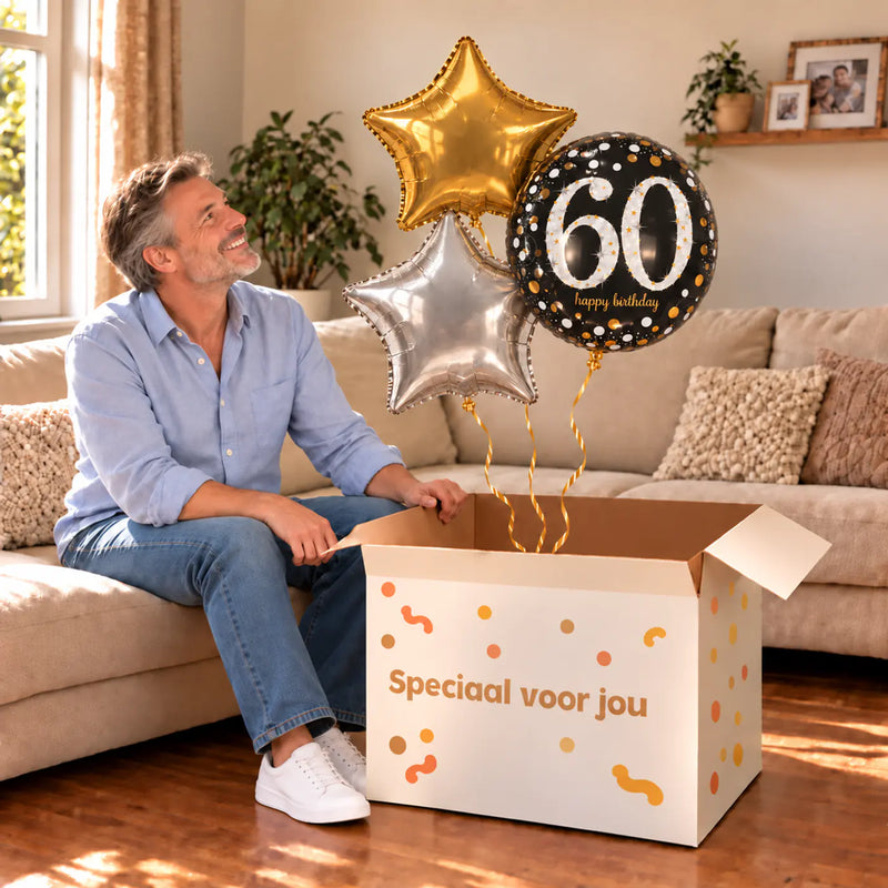 Een jarige met 60 Jaar Trosje Zilver/Zwart/Goud boven een open Speciaal voor jou-doos in een warme woonkamer.