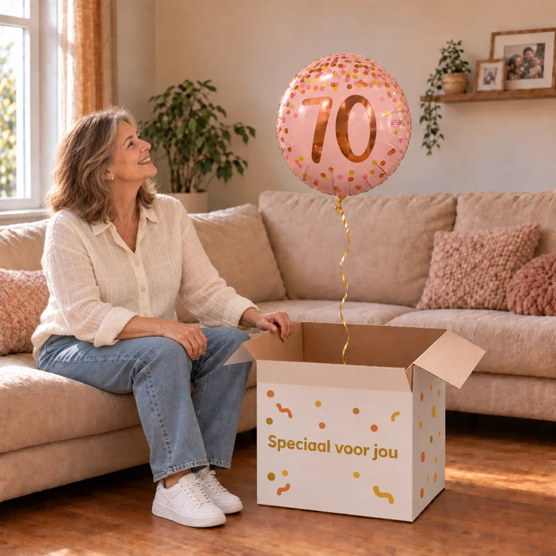 Vrouw viert 70 jaar met 70 Jaar Helium Ballon Roze uit een cadeaudoos van Ballonnenshop.nl