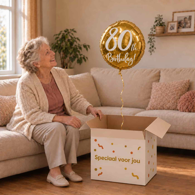 Vrouw van 80 jaar ontvangt een gouden 80th Birthday heliumballon van 45 cm uit een Ballonnenshop-cadeaudoos.