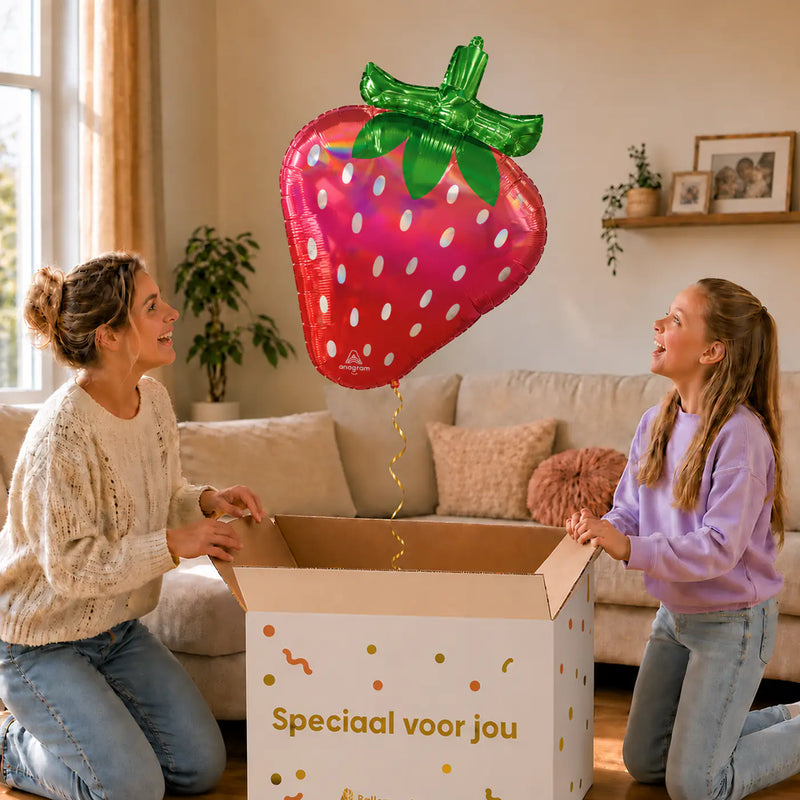 Aardbei Holographic Iridescent – uitpakmoment met moeder en meisje in een warme woonkamer – Ballonnenshop.nl