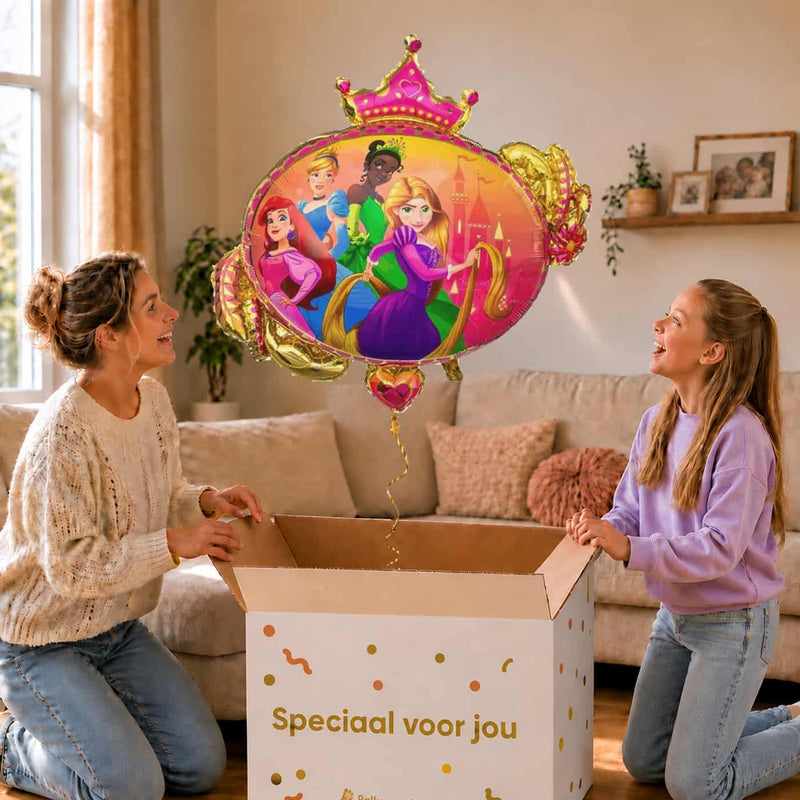 Moeder en meisje bekijken een Disney-prinsessenballon met Ariel, Assepoester, Tiana en Rapunzel van 86 cm met gouden lint boven de geopende cadeaudoos ‘Speciaal voor jou’.