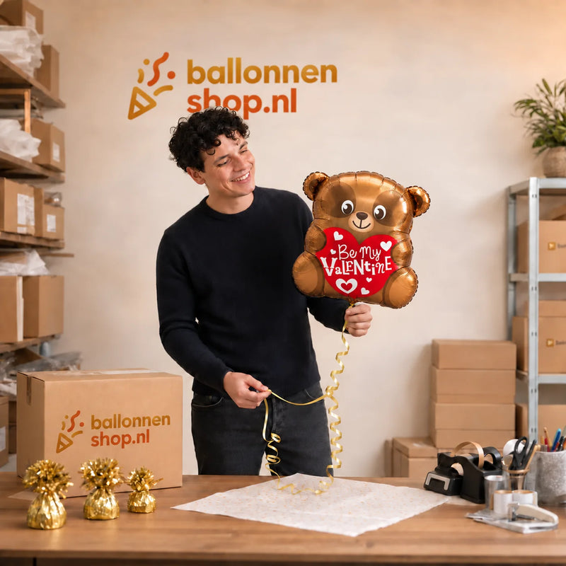 Jesse houdt de Be My Valentine Beertje – Zacht Gebaar vast in de warme werkplaats van Ballonnenshop.nl.