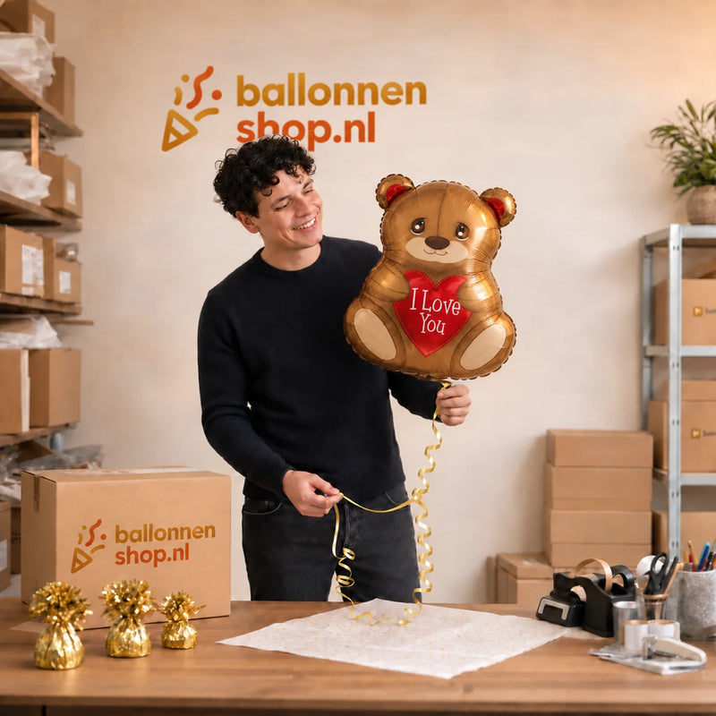 Jesse houdt de Beertje I Love You Ballon – 45 cm vast in de warme werkplaats van Ballonnenshop.nl.