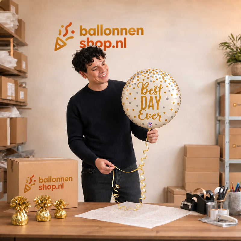 Jesse houdt de Best Day Ever Helium Ballon vast in de warme werkplaats van Ballonnenshop.nl.