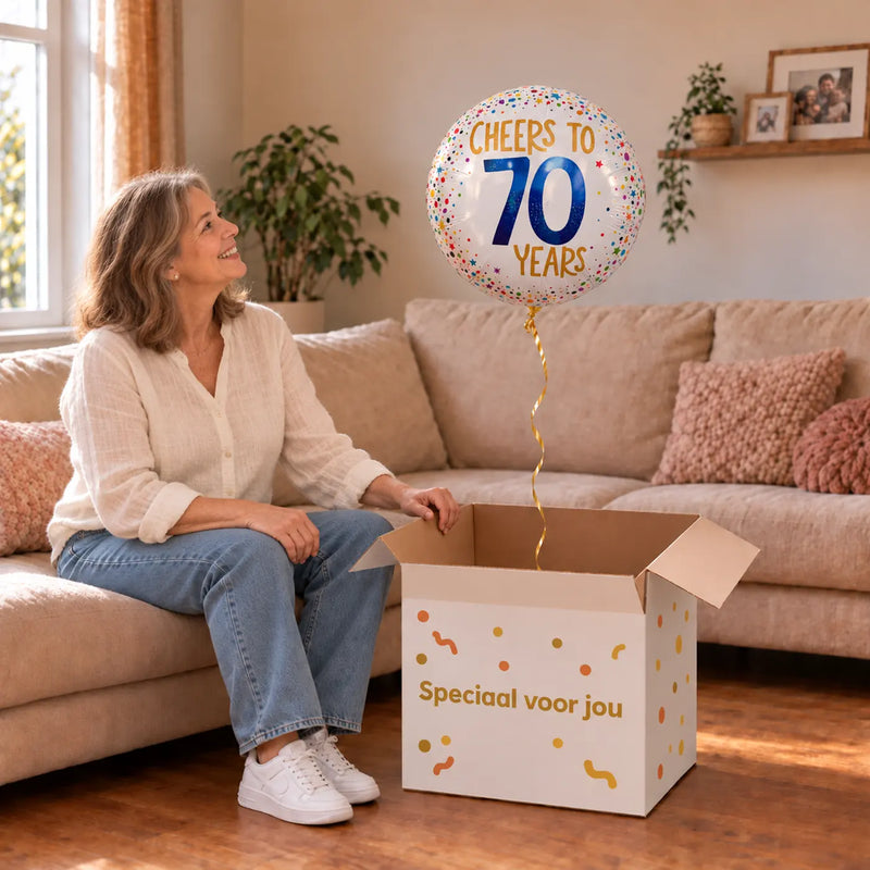 Vrouw viert 70 jaar met Cheers To 70 Years Helium Ballon uit een cadeaudoos van Ballonnenshop.nl