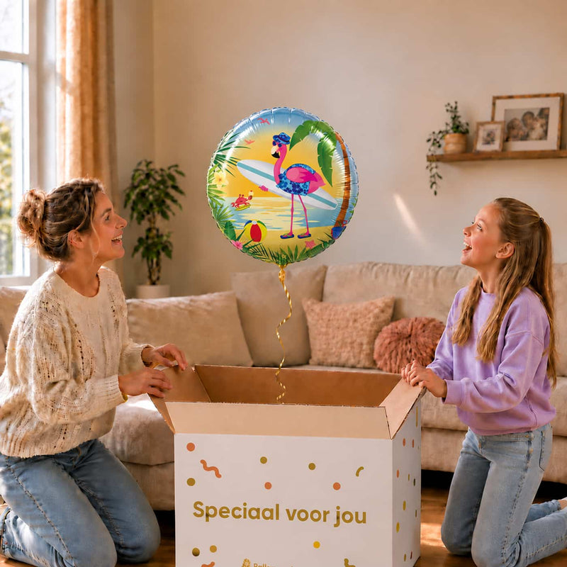 Moeder en meisje bekijken een ronde heliumballon van 45 cm met een flamingo op het strand boven de cadeaudoos.