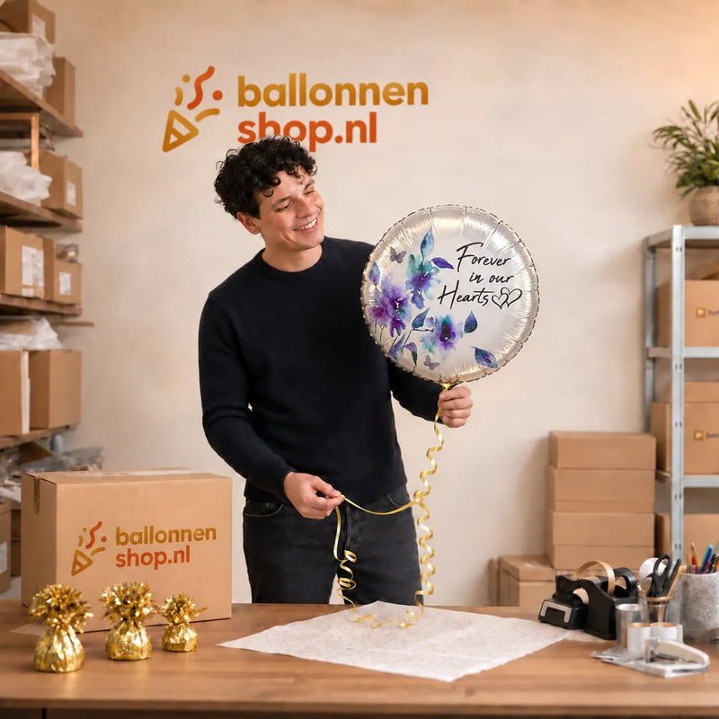 Jesse houdt de Forever In Our Hearts Ballon vast in de warme werkplaats van Ballonnenshop.nl.
