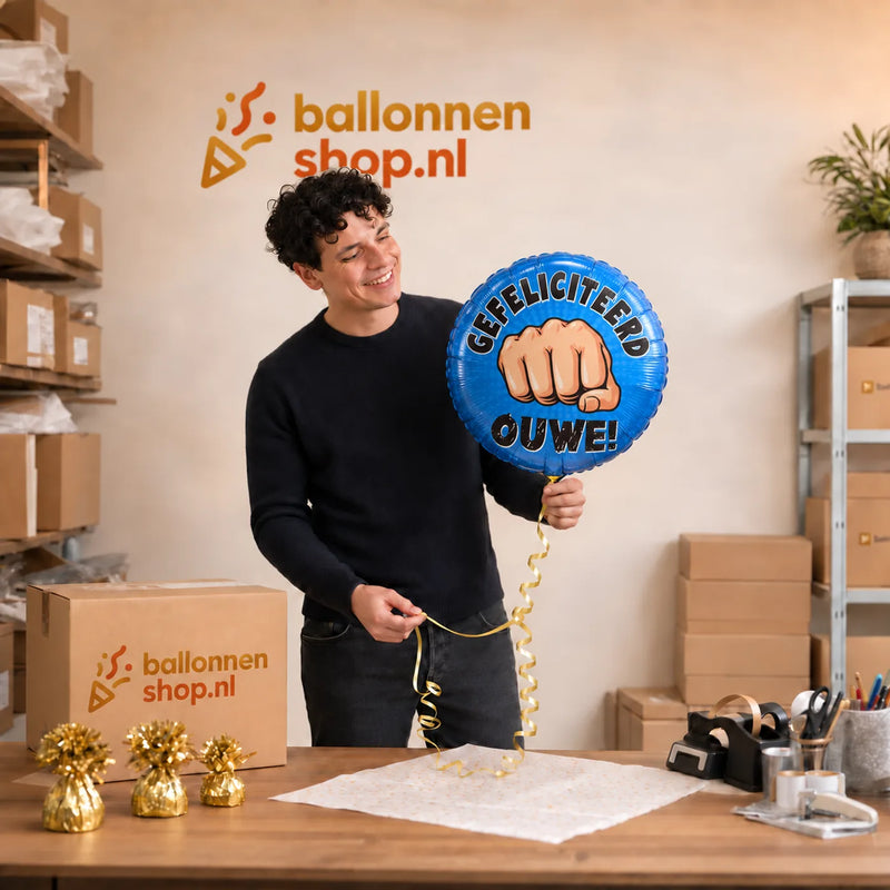 Jesse houdt de Gefeliciteerd Ouwe ballon vast in de warme werkplaats van Ballonnenshop.nl.