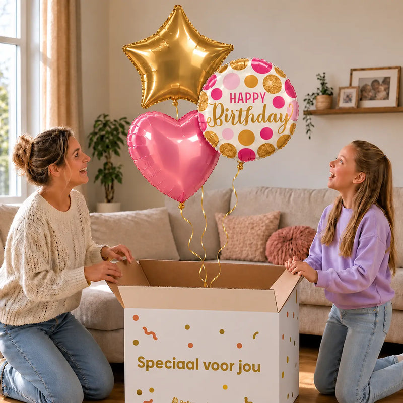Happy Birthday Roze/Goud/Wit Tros: moeder en dochter pakken het heliumgevulde ballonnentrosje uit een Speciaal voor jou-doos, met natuurlijk gekrulde gouden linten.