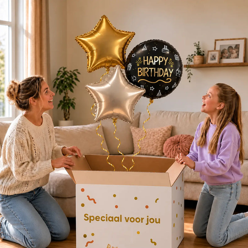 Happy Birthday Trosje Zilver/Zwart/Goud: moeder en dochter pakken het heliumgevulde ballonnentrosje uit een Speciaal voor jou-doos, met natuurlijk gekrulde gouden linten.