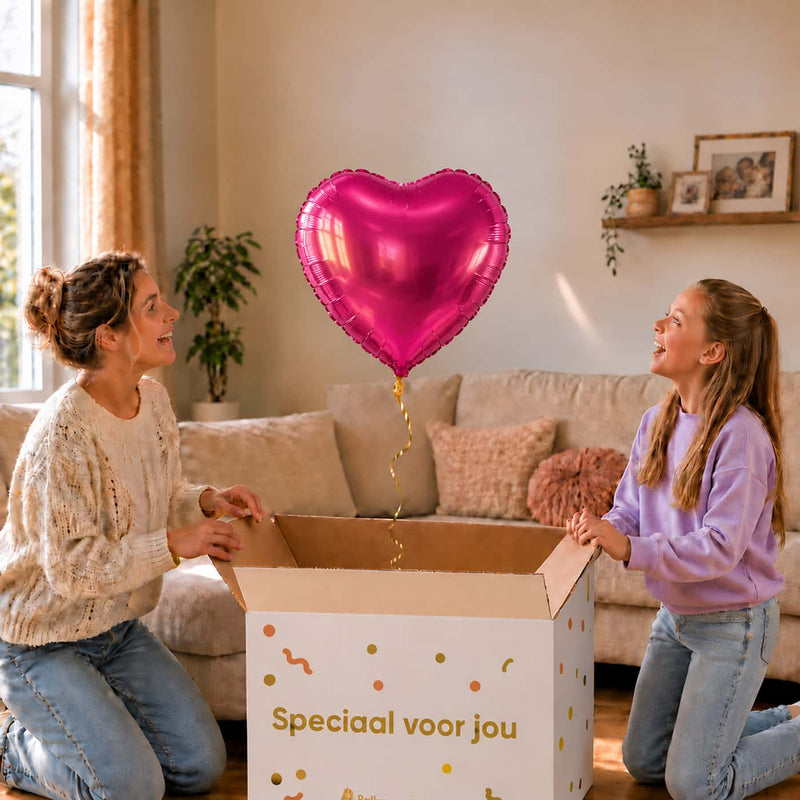Moeder en meisje kijken naar een fuchsia hartvormige heliumballon van 46 cm boven de cadeaudoos.
