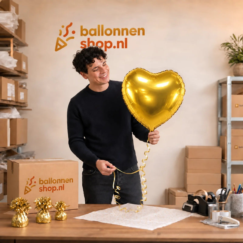 Jesse houdt de Hart Ballon Goud vast in de warme werkplaats van Ballonnenshop.nl.