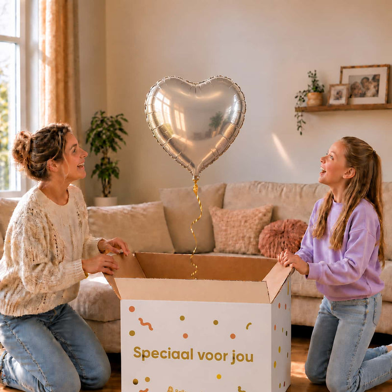 Moeder en meisje openen een cadeaudoos met een zilveren hartvormige heliumballon van 46 cm.