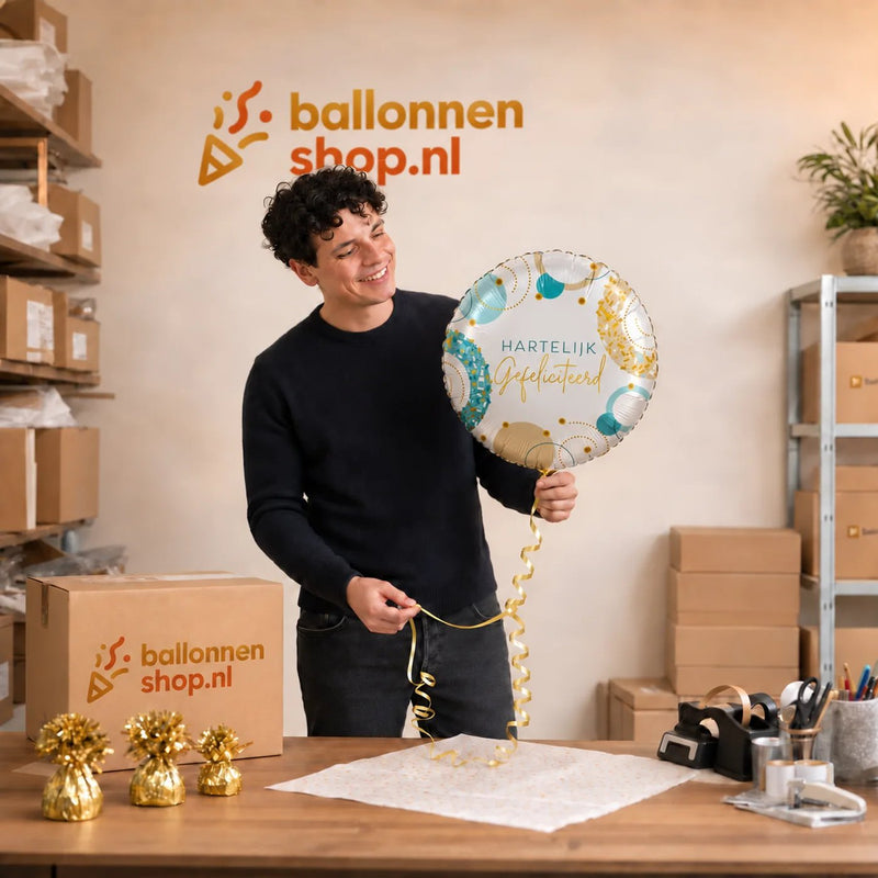 Jesse houdt de Hartelijk Gefeliciteerd Ballon vast in de warme werkplaats van Ballonnenshop.nl.