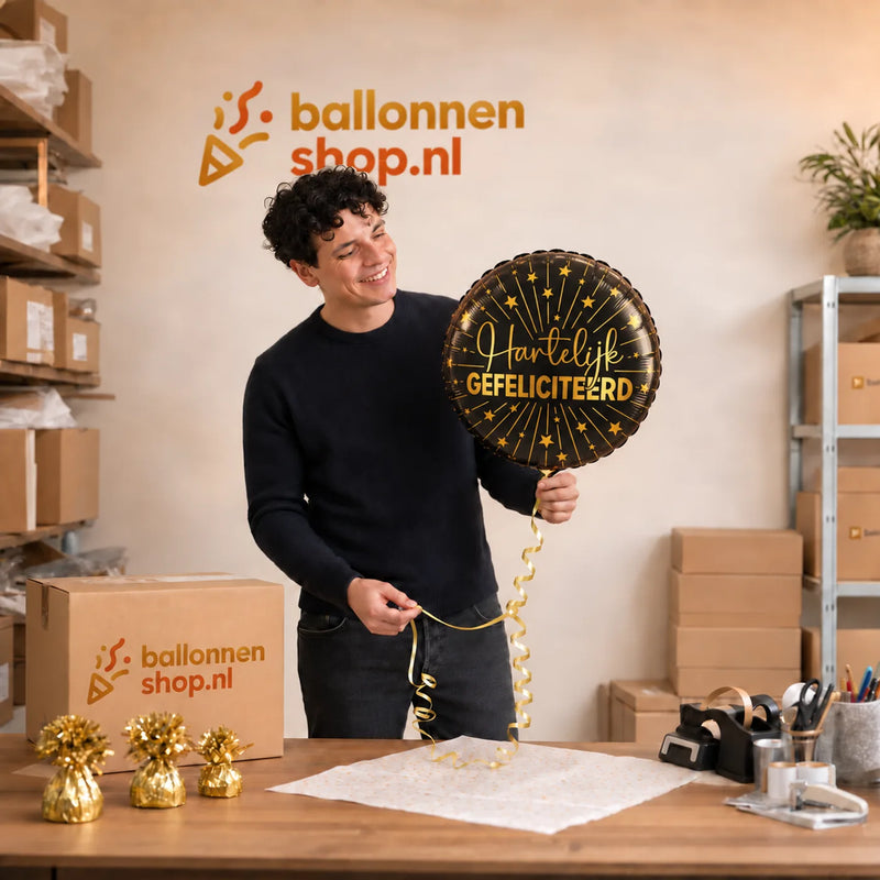 Jesse houdt de Hartelijk Gefeliciteerd Ballon vast in de warme werkplaats van Ballonnenshop.nl.