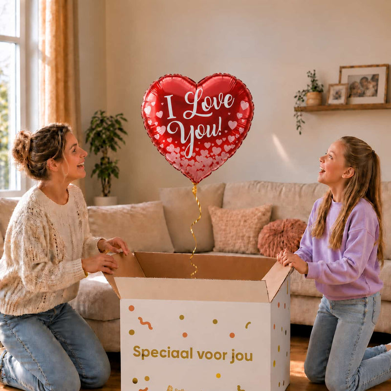 Moeder en meisje bekijken een rode I Love You hartballon van 43 cm met een rand van roze hartjes boven de open cadeaudoos.