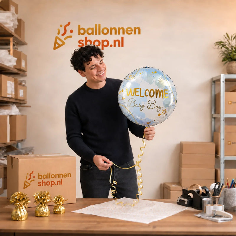 Jesse houdt de Helium Ballon Welcome Baby Boy vast in de warme werkplaats van Ballonnenshop.nl.