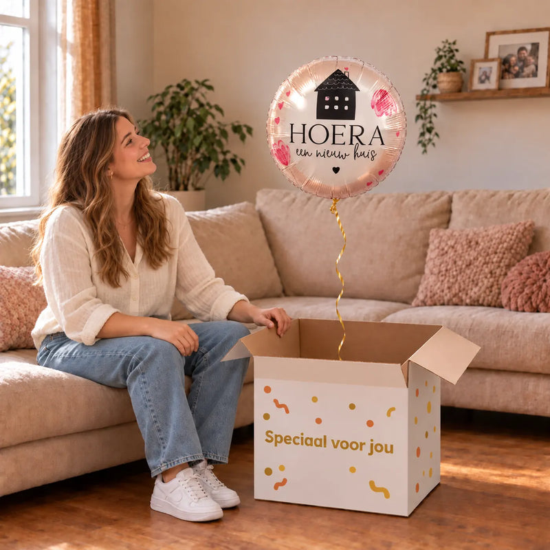 Uitpakmoment met Hoera Een Nieuw Huis Ballon uit een cadeaudoos van Ballonnenshop.nl