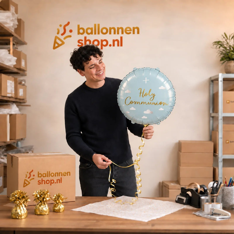Jesse houdt de Holy Communion Helium Ballon vast in de warme werkplaats van Ballonnenshop.nl.
