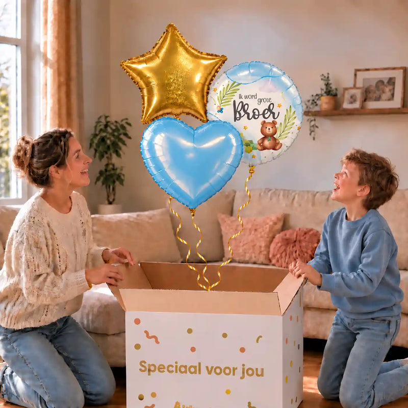 Ik Word Grote Broer Trosje: moeder en zoon pakken het heliumgevulde ballonnentrosje uit een Speciaal voor jou-doos, met natuurlijk gekrulde gouden linten.
