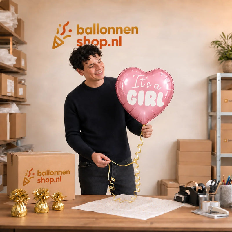 Jesse houdt de It's A Girl Helium Ballon vast in de warme werkplaats van Ballonnenshop.nl.