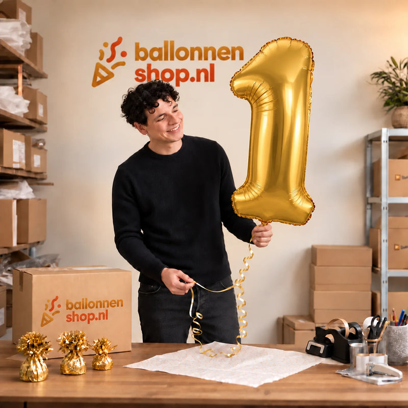 Jesse houdt de 1 Jaar Cijfer Goud XL Ballon vast in de warme inpakruimte van Ballonnenshop.nl.