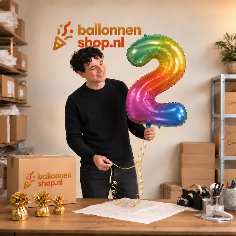 Jesse houdt de 2 Jaar Cijfer Yummy Gummy XL vast in de warme inpakruimte van Ballonnenshop.nl.