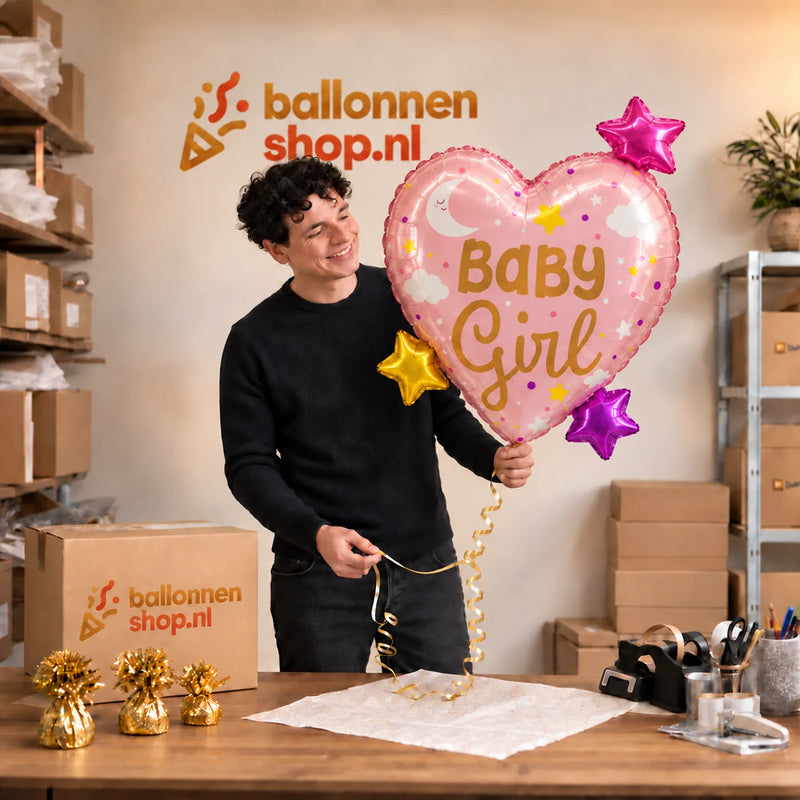 Jesse houdt de Baby Girl Hart Sterren XL Ballon vast in de warme inpakruimte van Ballonnenshop.nl.