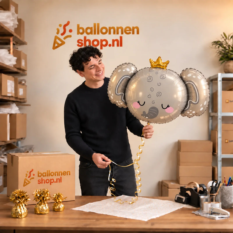 Jesse houdt de Baby Olifant Helium Ballon vast in de warme inpakruimte van Ballonnenshop.nl.