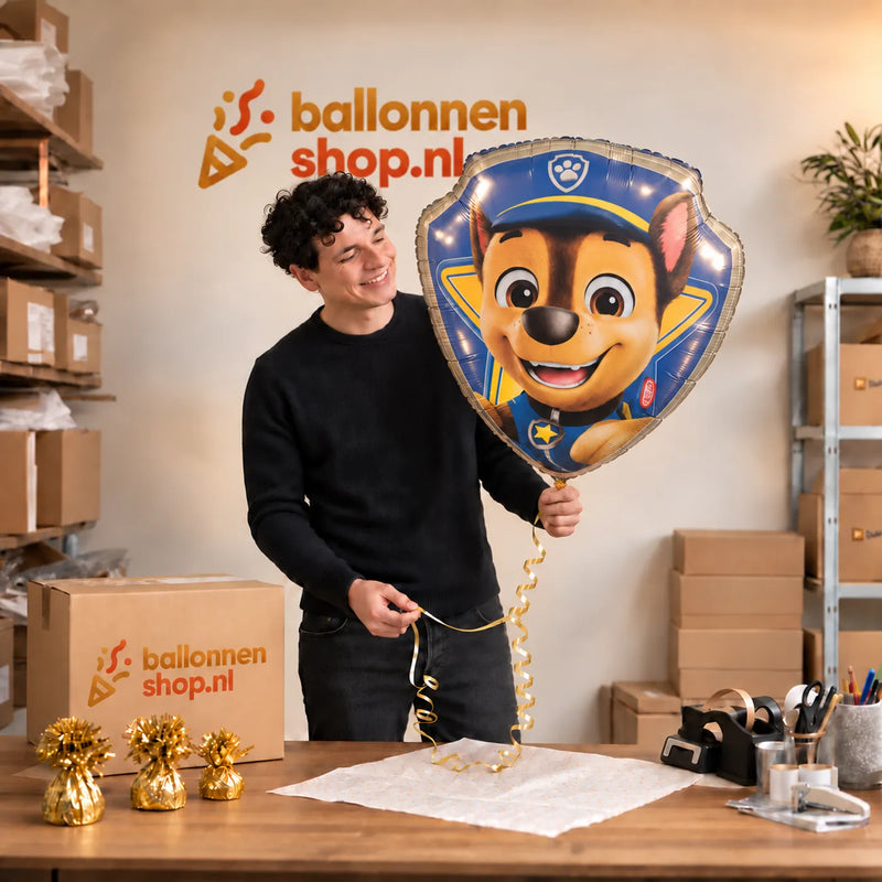 Jesse houdt de Chase Paw Patrol Helium XL Ballon vast in de warme inpakruimte van Ballonnenshop.nl.