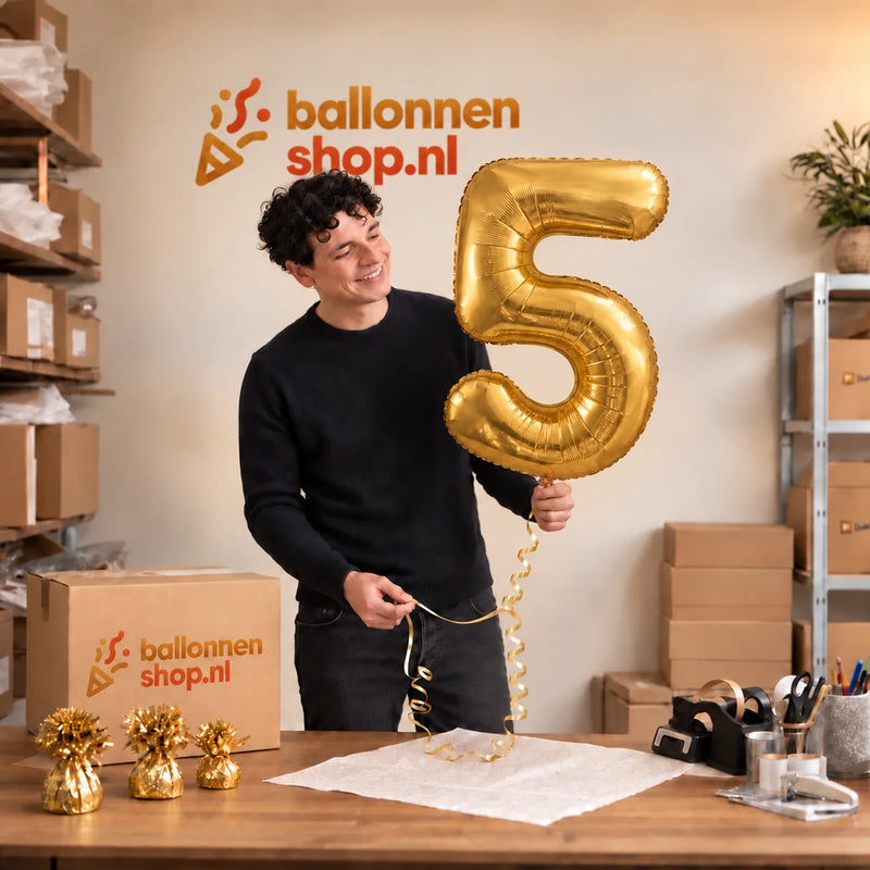 Jesse houdt de Cijfer 5 Helium Ballon Goud vast in de warme inpakruimte van Ballonnenshop.nl.