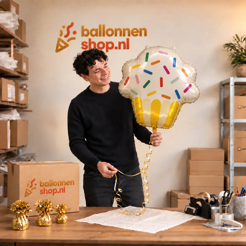 Jesse houdt de Cupcake Helium XL Ballon vast in de warme inpakruimte van Ballonnenshop.nl.