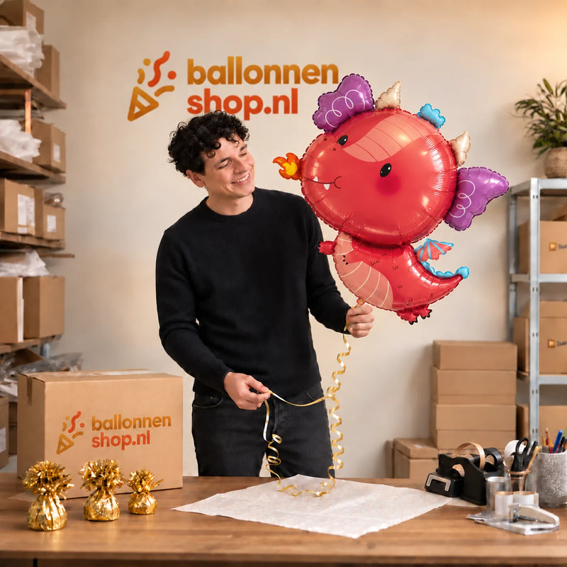 Jesse houdt de Draak Dino Helium XL Ballon vast in de warme inpakruimte van Ballonnenshop.nl.