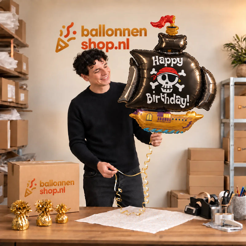 Jesse houdt de Happy Birthday Piratenschip XL vast in de warme inpakruimte van Ballonnenshop.nl.