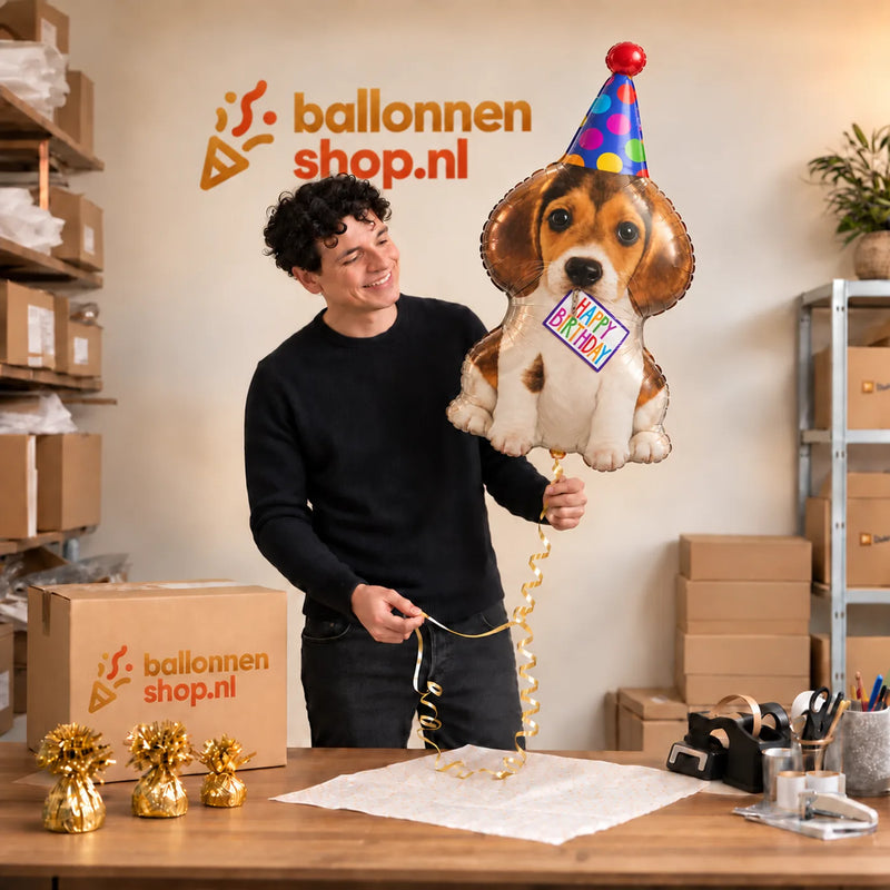 Jesse houdt de Happy Birthday Puppy XL Ballon vast in de warme inpakruimte van Ballonnenshop.nl.