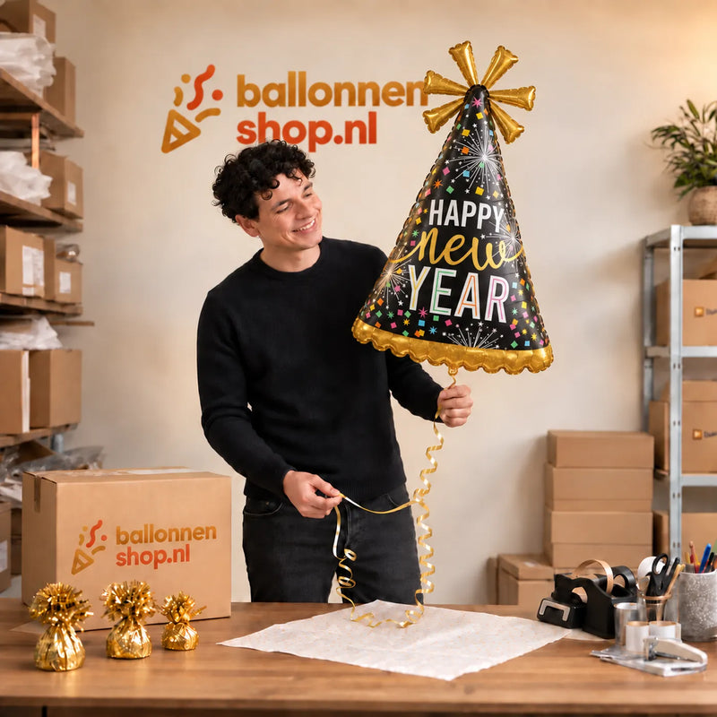 Jesse houdt de Happy New Year Feesthoed XL vast in de warme inpakruimte van Ballonnenshop.nl.