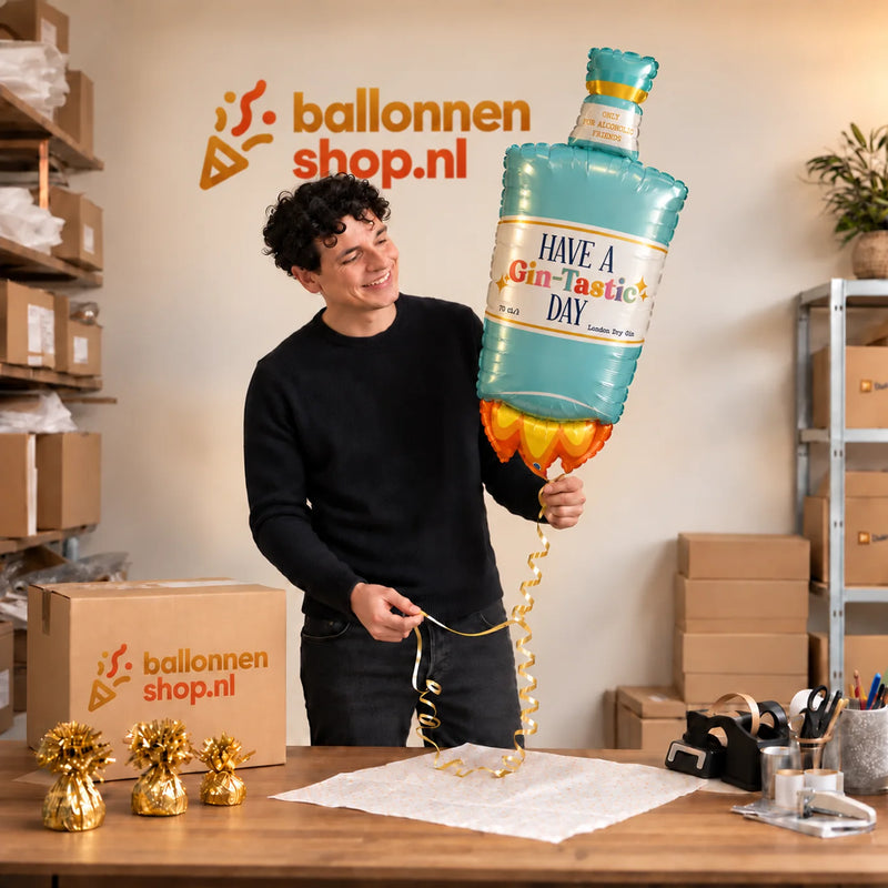 Jesse houdt de Have A Gin – Tastic Day XL Ballon vast in de warme inpakruimte van Ballonnenshop.nl.
