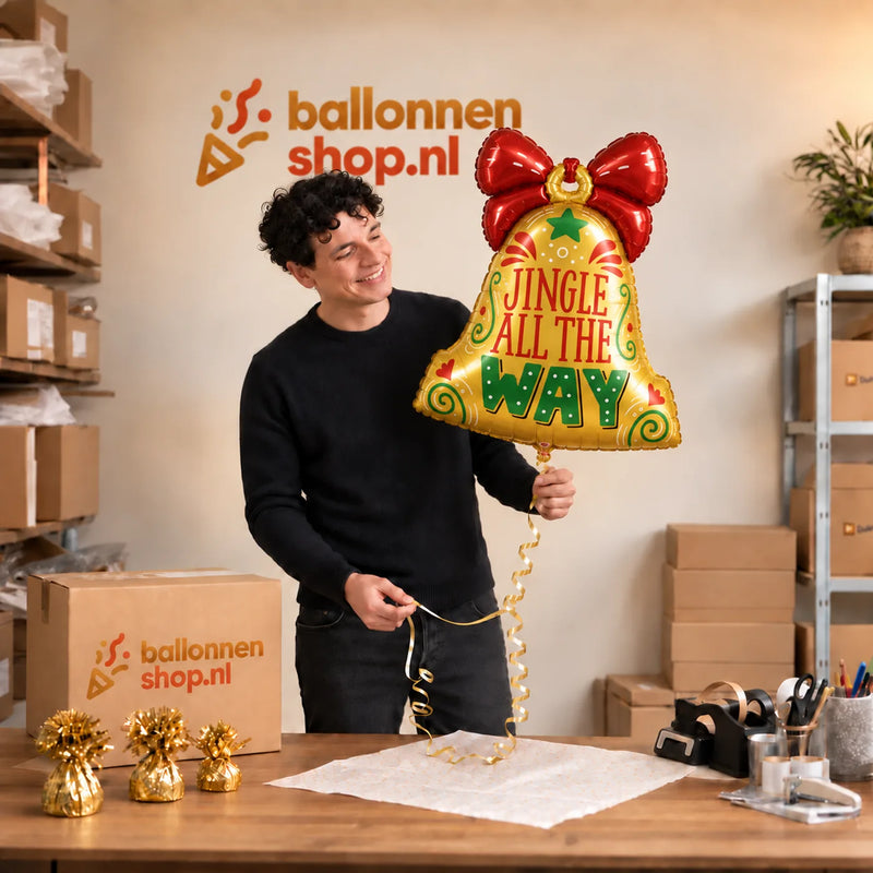 Jesse houdt de Jingle All The Way Bel Ballon vast in de warme inpakruimte van Ballonnenshop.nl.