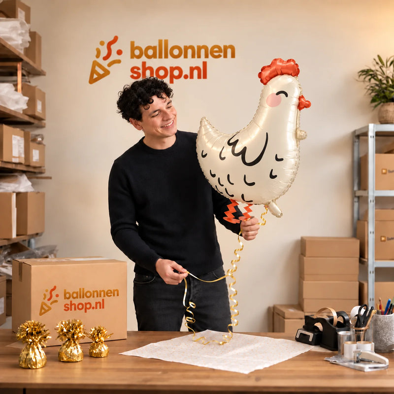 Jesse houdt de Wandelende Kip Helium Ballon vast in de warme inpakruimte van Ballonnenshop.nl.