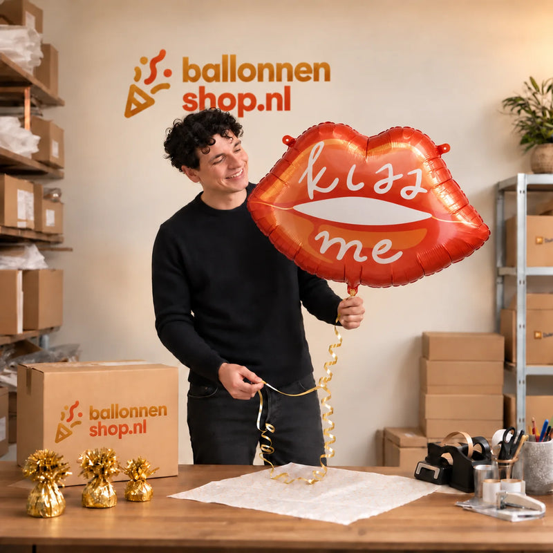 Jesse houdt de Kiss Me Helium XL Ballon vast in de warme inpakruimte van Ballonnenshop.nl.