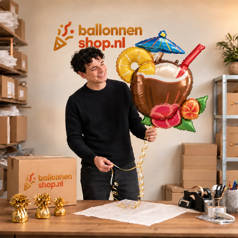 Jesse houdt de Kokosnoot Cocktail Pina Colada XL vast in de warme inpakruimte van Ballonnenshop.nl.