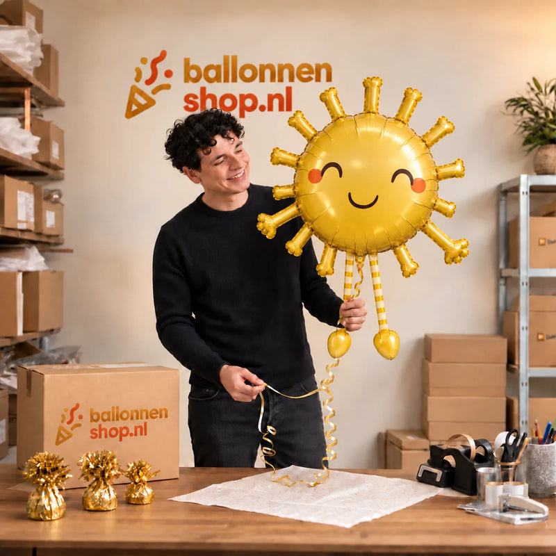 Jesse houdt de Lopende Zon Helium XL Ballon vast in de warme inpakruimte van Ballonnenshop.nl.