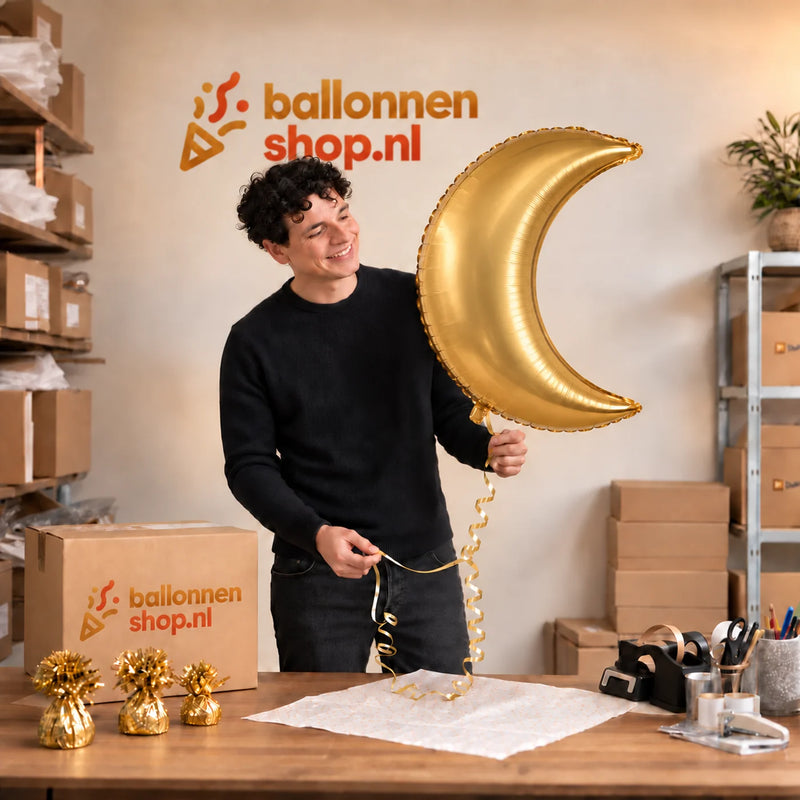 Jesse houdt de Maan Helium Ballon vast in de warme inpakruimte van Ballonnenshop.nl.